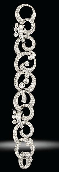 A diamond bracelet composed of a graduated series of openwork scrolls pavé-set ...