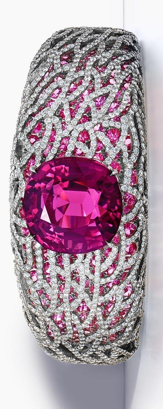 A magnificent rubellite is surrounded by a sea of pink sapphires and diamonds in...