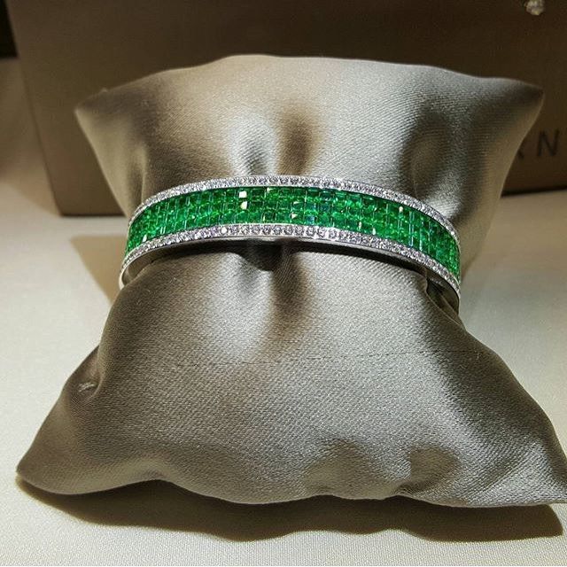 Invisible setting emeralds surrounded by white diamonds for a unique masterpiece...