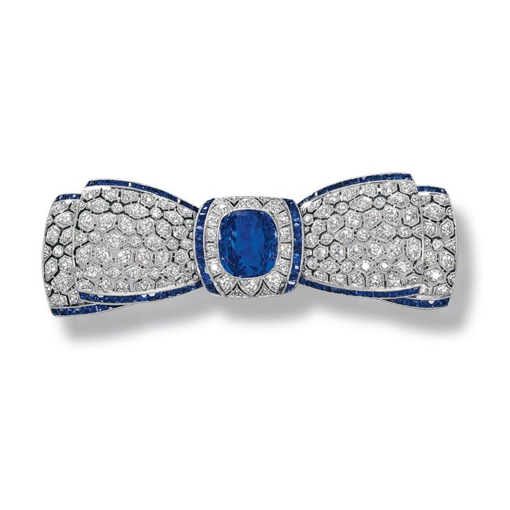 SAPPHIRE AND DIAMOND BROOCH, CIRCA 1915 Designed as an openwork bow set with cir...