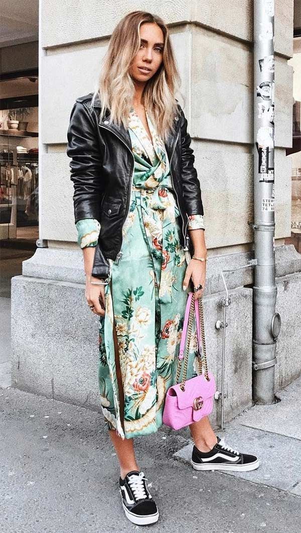 Lisa Olsson usa vestido floral midi, jaqueta de couro, vans e bolsa pink.