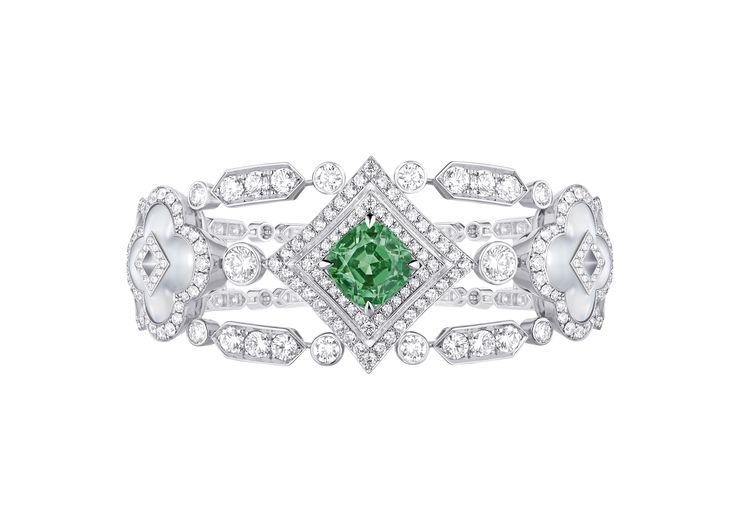 An abundance of diamonds and moonstone dance around this strong green tsavorite...