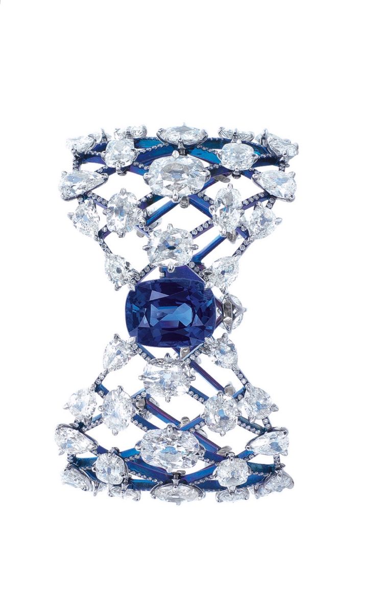 AN UNUSUAL SAPPHIRE AND DIAMOND BANGLE, BY FORMS. The tapered openwork hinged ba...