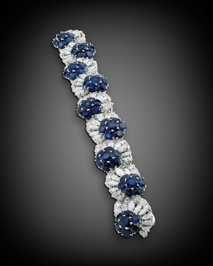Sapphire flowers bloom in this stunning bracelet. Comprised of approximately 27....