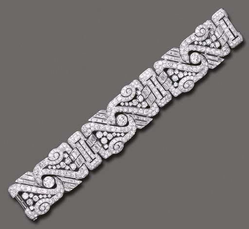 AN ART DECO DIAMOND BRACELET The wide flexible band composed of three openwork o...